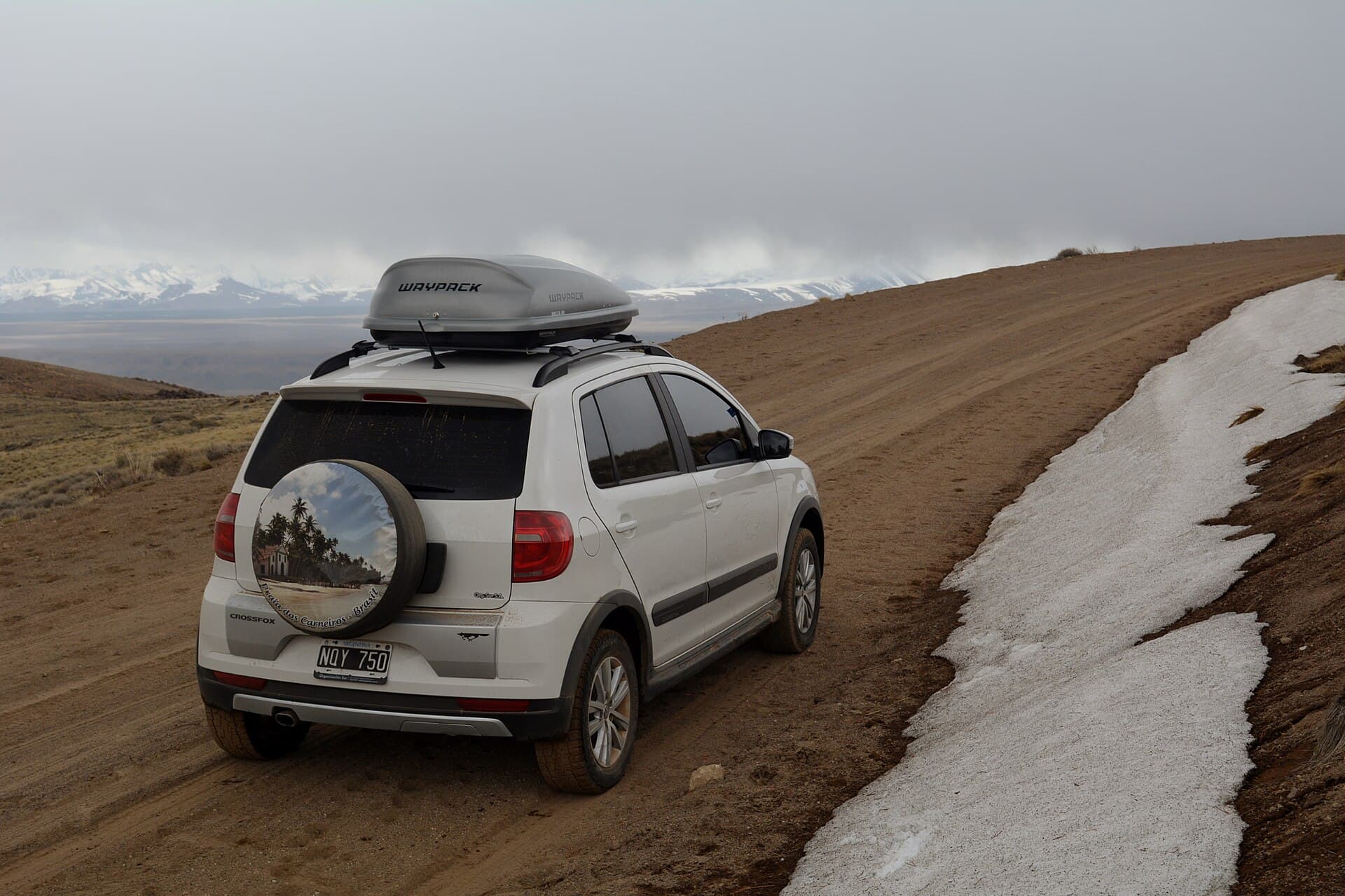 The ripio road to the Domuyo hot springs with snow at the verge